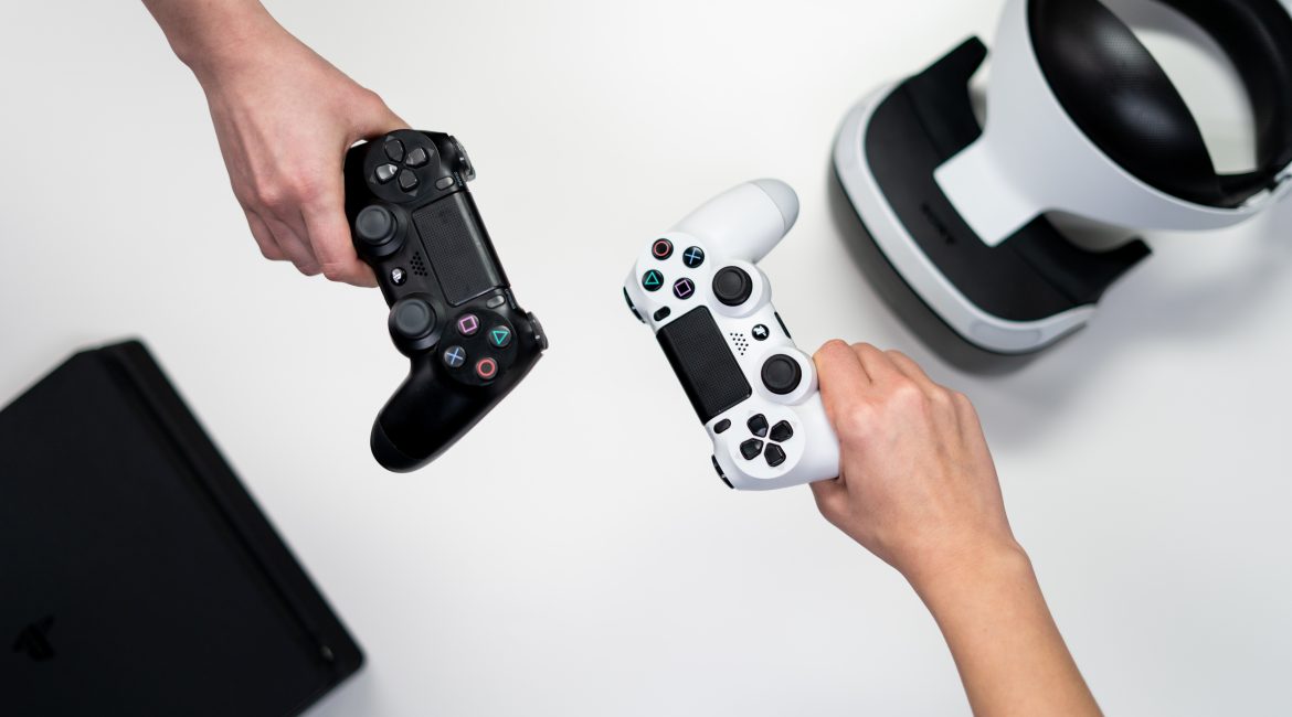 Manos de personas sosteniendo controles blanco y negro de Xbox One